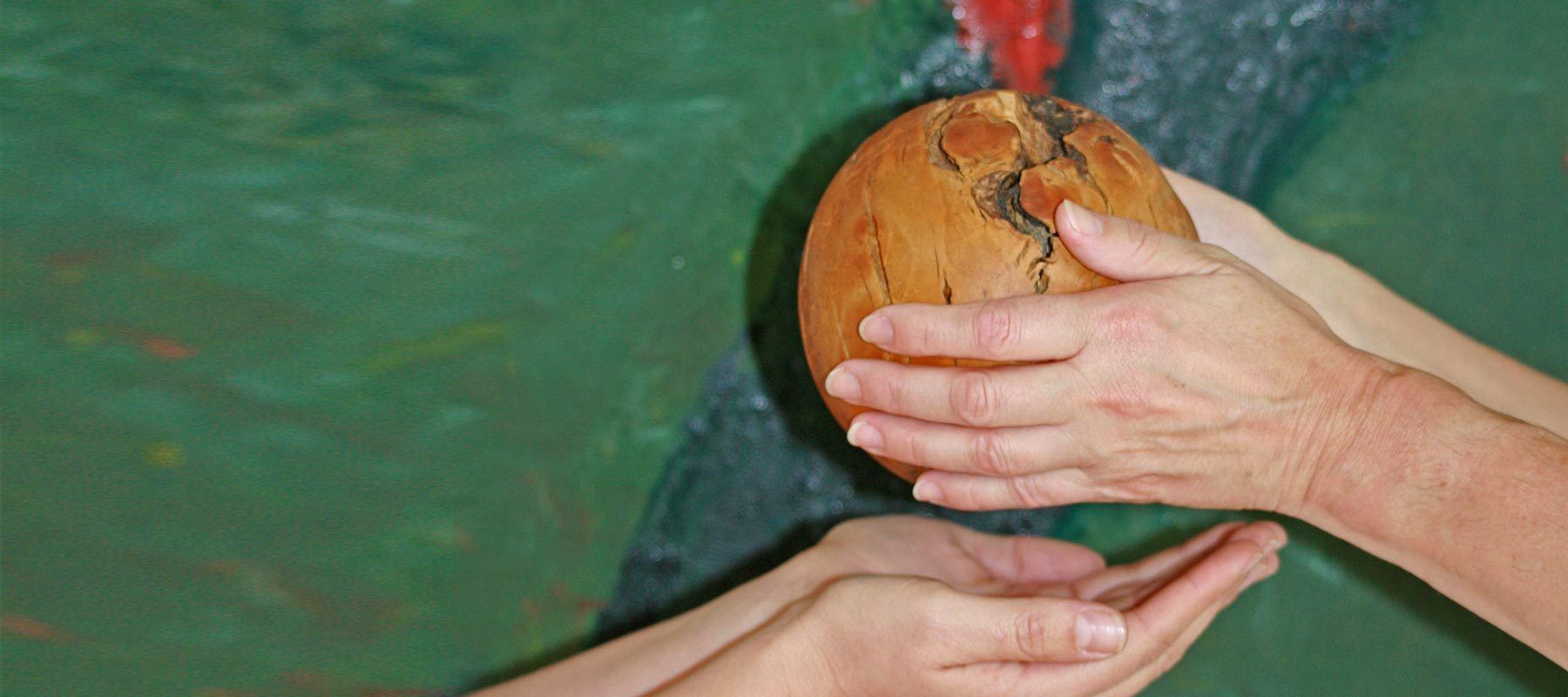 Ein Ball aus Holz wird übergeben